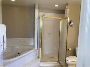 Bathroom featuring a marble finish shower, recessed lighting, and a bath