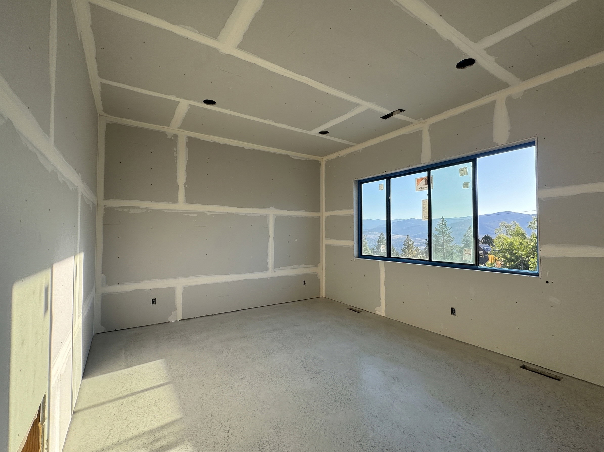 Expansive room with vaulted ceilings and recessed lighting