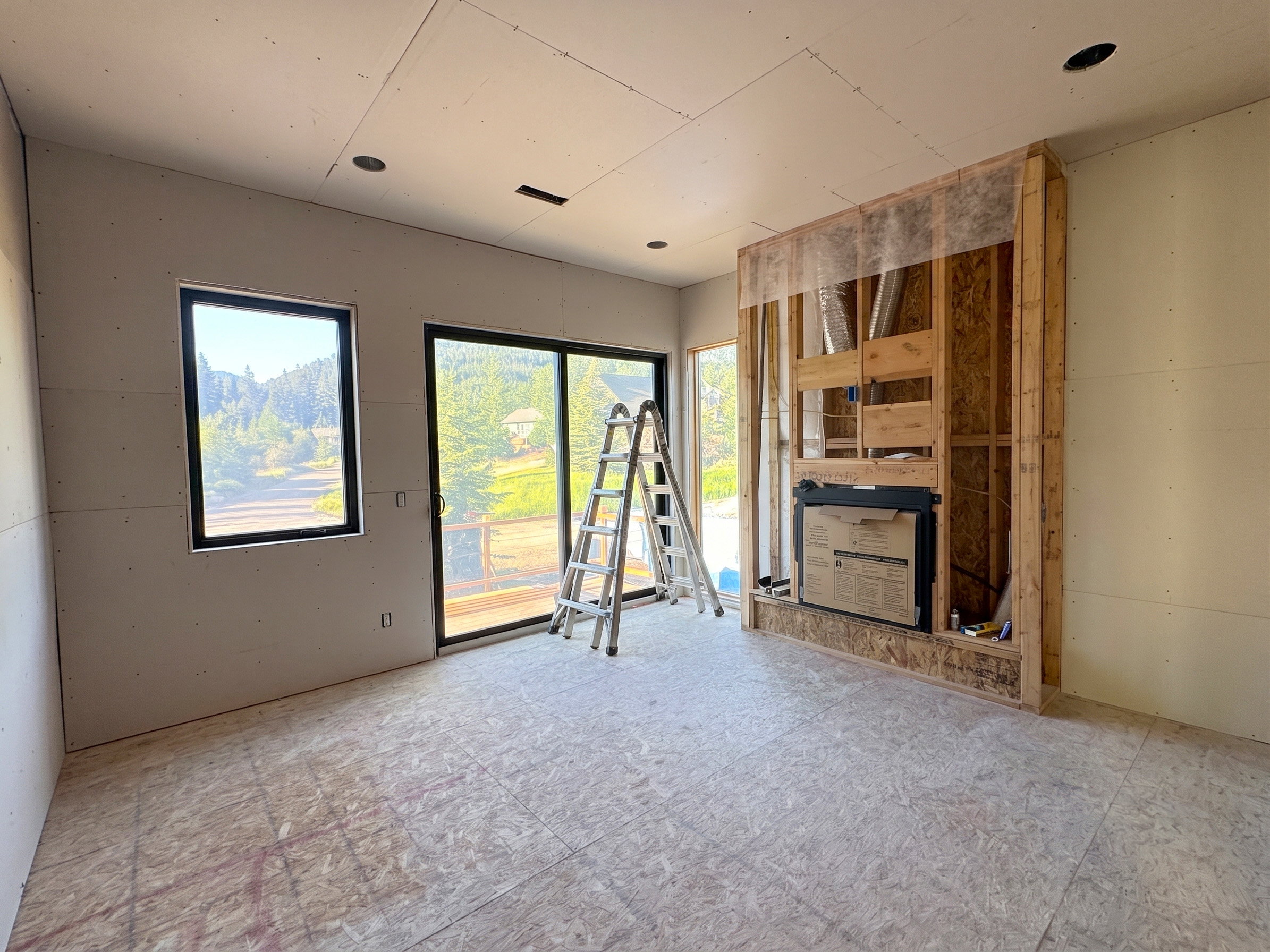 Interior space under construction featuring a built-in fireplace structure and recessed lighting