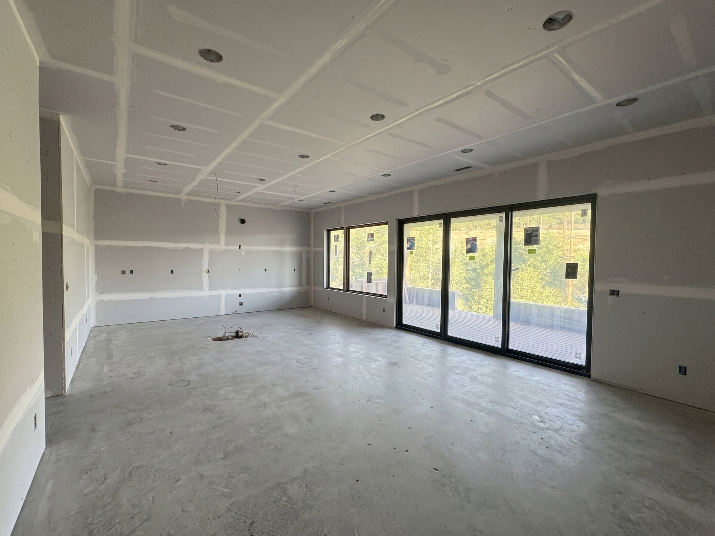 Spacious interior featuring a concrete floor, recessed ceiling lighting, and expansive sliding glass doors