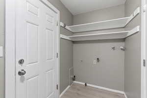 Laundry area with hookup for a gas dryer, washer hookup, and light wood-type flooring