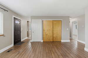 Foyer entrance with light wood-style floors and baseboards
