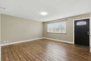 Entrance foyer with wood-type flooring and baseboards