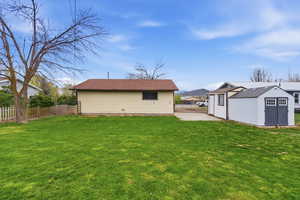 Fenced backyard featuring a mountain view and a storage shed