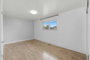 Empty room featuring light wood-style flooring and baseboards