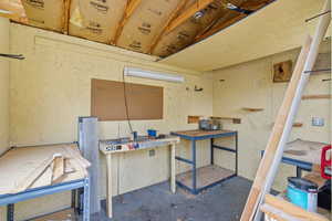 Misc room featuring unfinished concrete floors and a workshop area