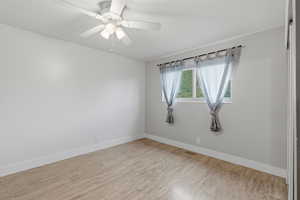 Spare room featuring light wood-type flooring and a ceiling fan