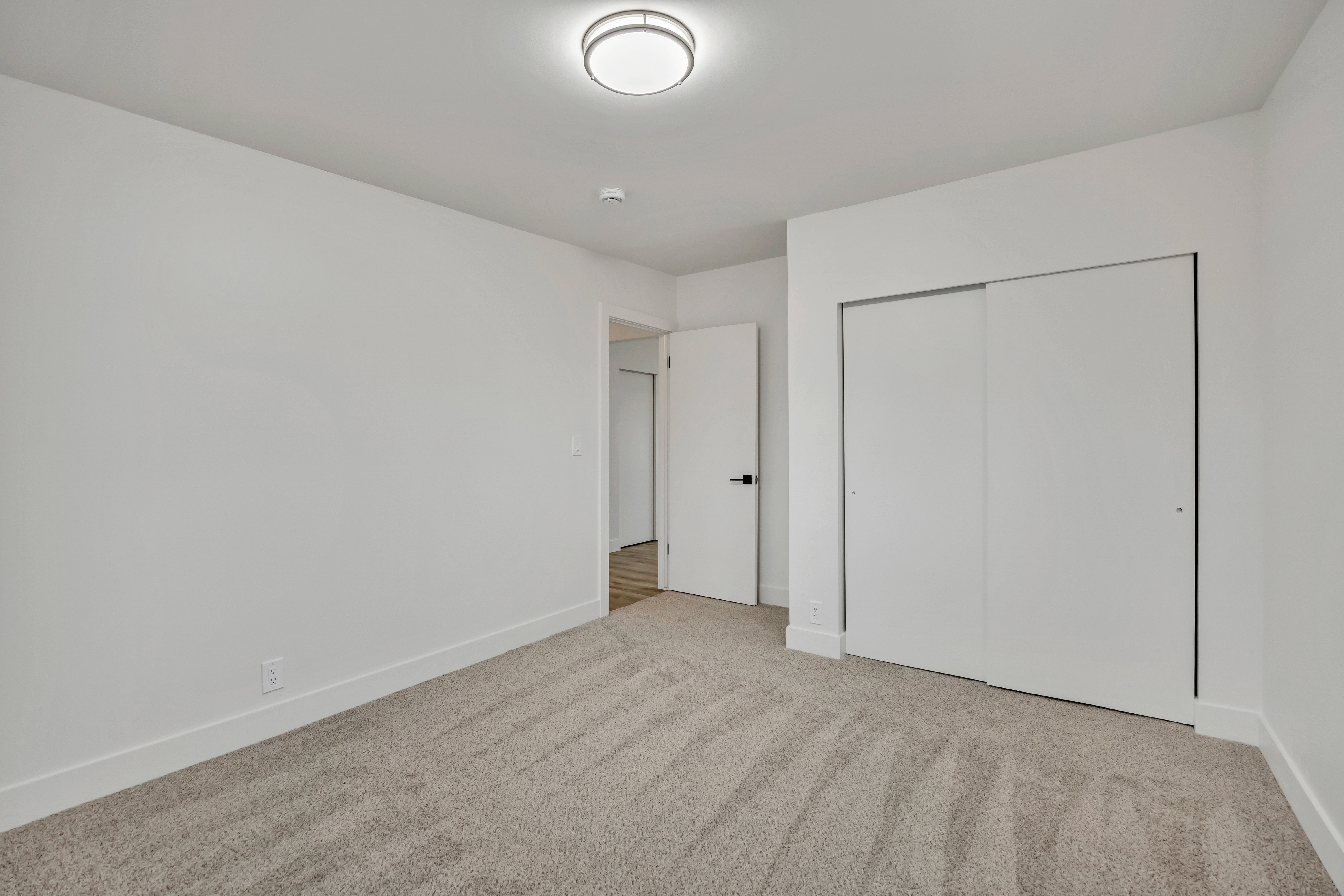 Unfurnished bedroom with light carpet and a closet