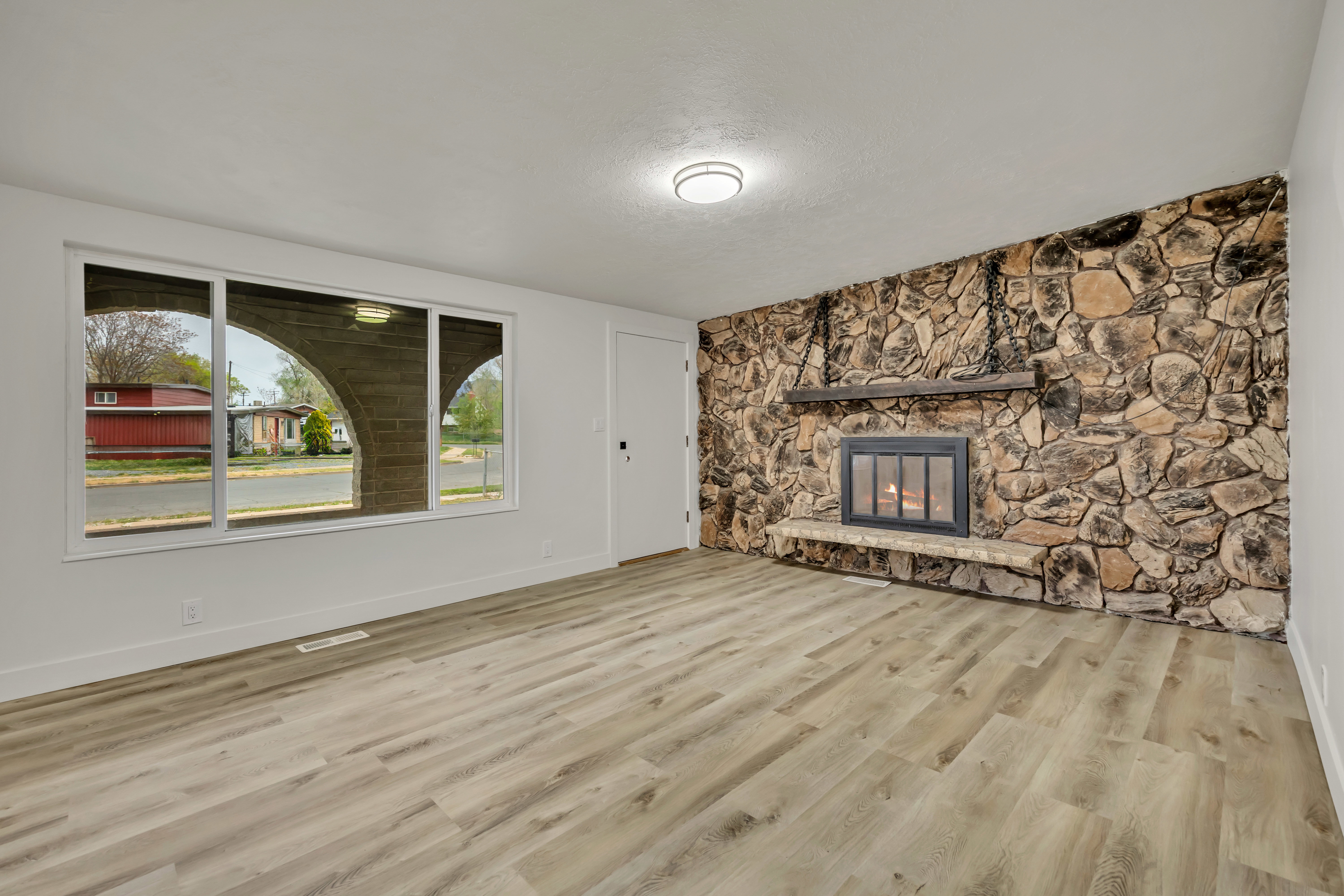Unfurnished living room with a fireplace, light wood-style flooring, and an accent wall