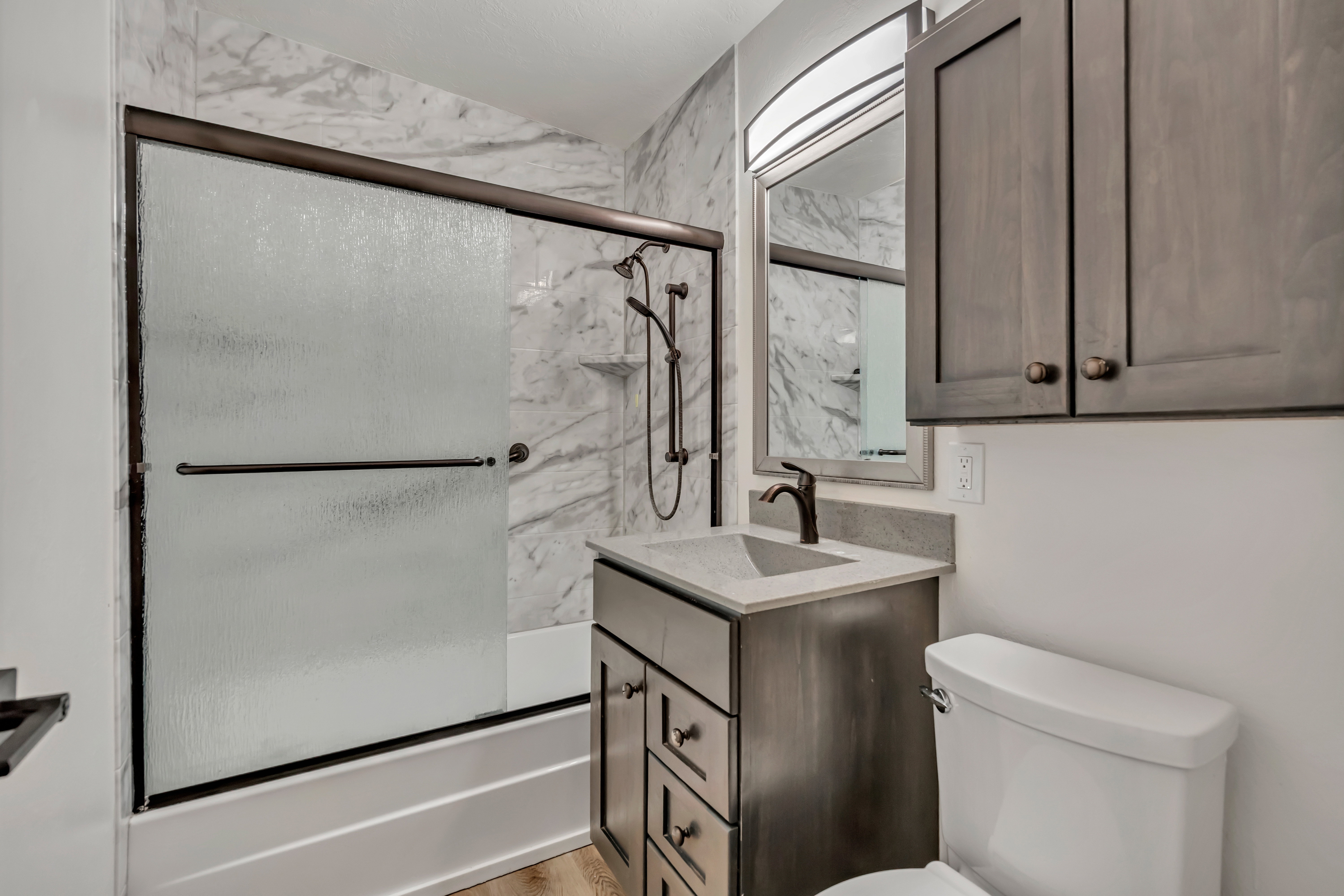 Full bathroom with enclosed tub / shower combo and vanity