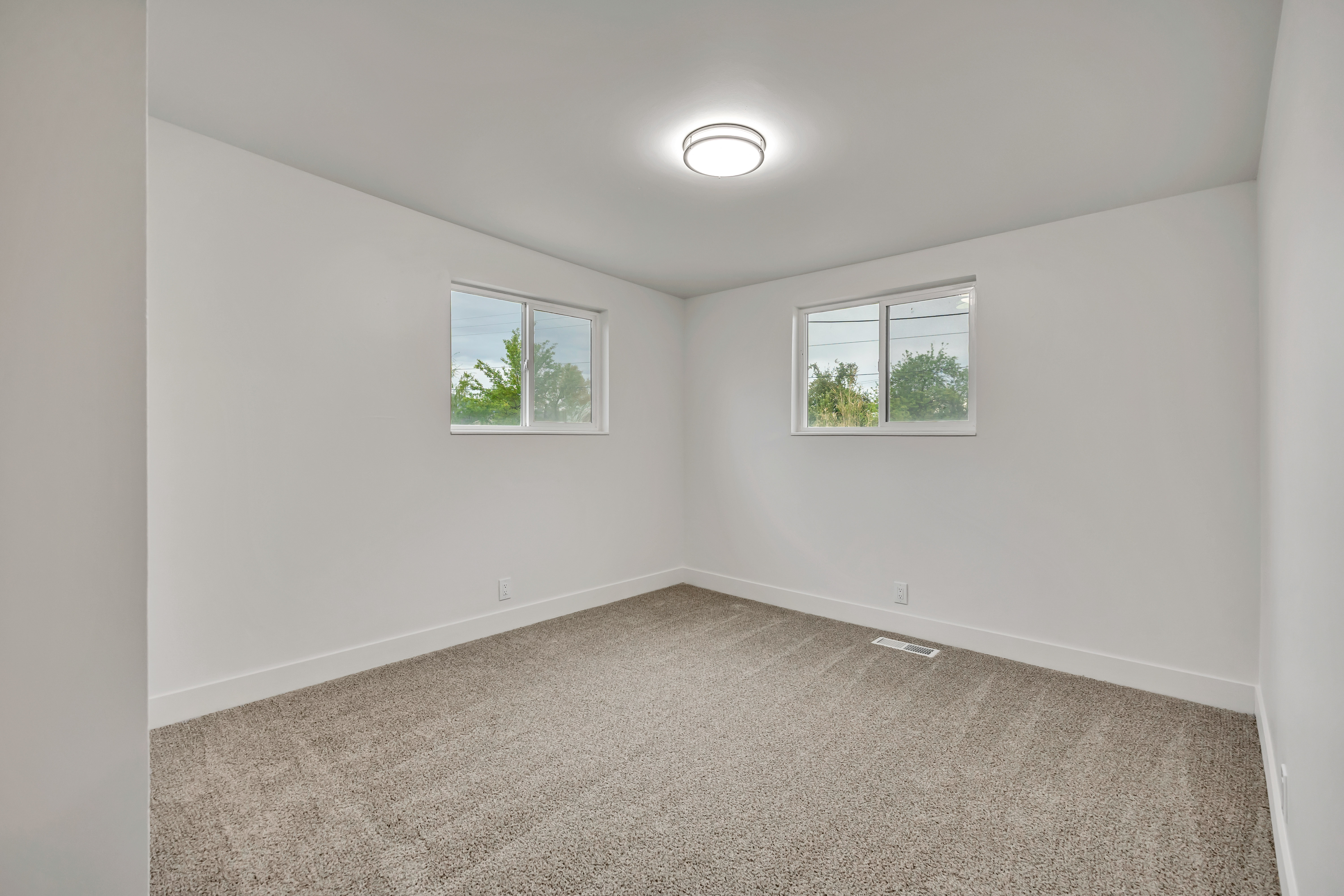 Spare room featuring light colored carpet and baseboards