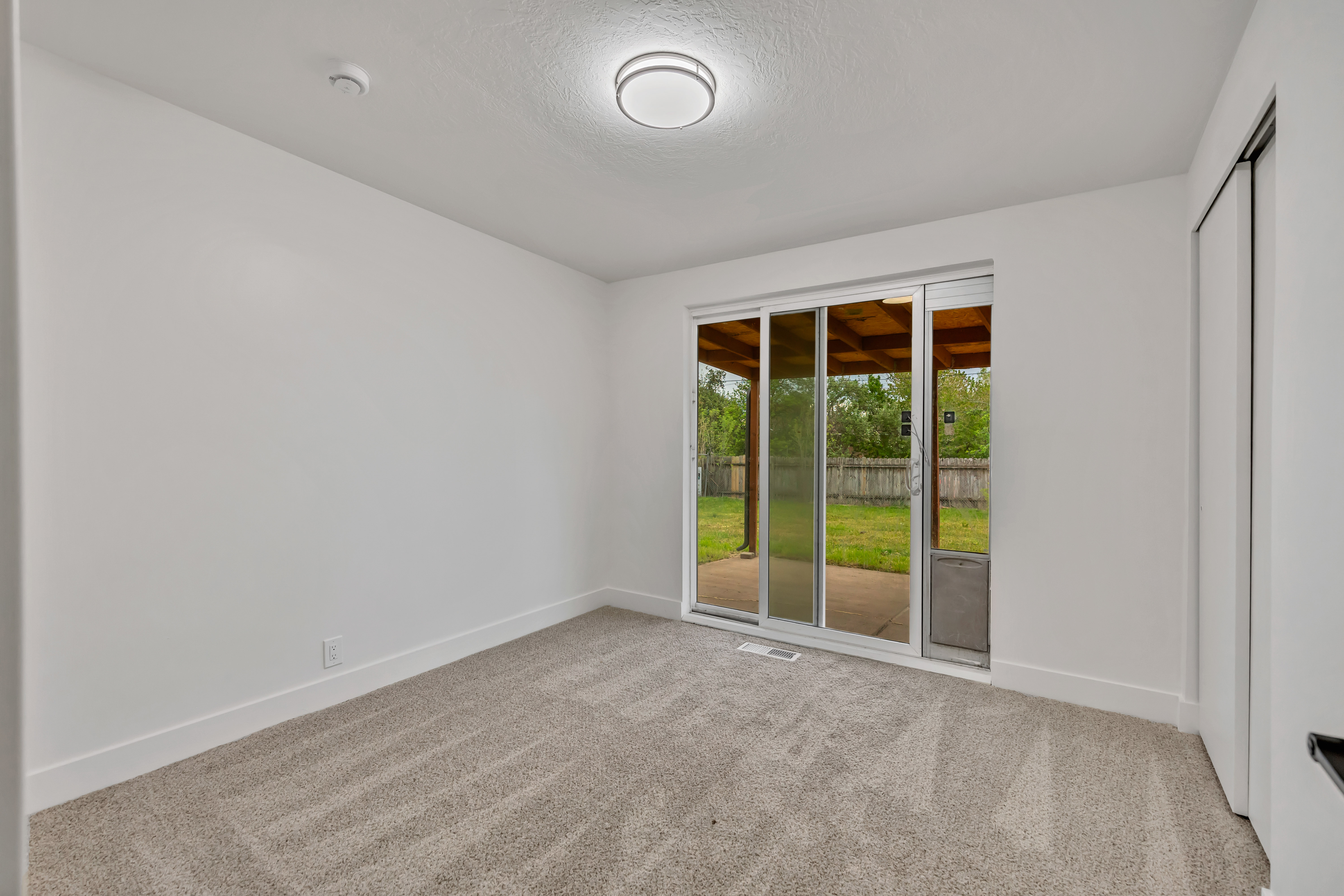 Unfurnished room featuring light carpet and a textured ceiling