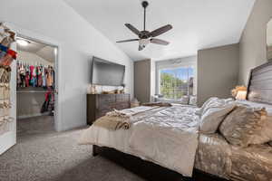 Primary Suite  New carpet with vaulted ceiling, a spacious walk in closet closet, and ceiling fan