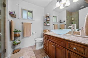 Full bathroom with a shower stall, stone tile flooring, and vanity
