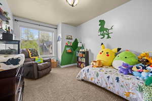 Bedroom featuring light carpet and baseboards