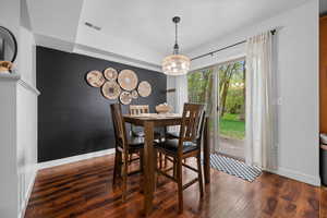 Dining room with wood finished floors and suspended lighting