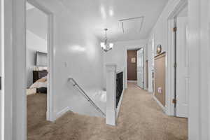 Hallway with an upstairs landing and light carpet