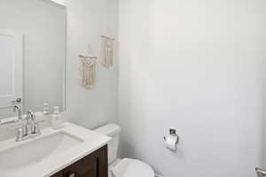 Half bathroom featuring vanity and toilet