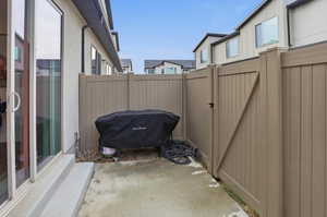 View of patio featuring a gate, grilling area, and a residential view