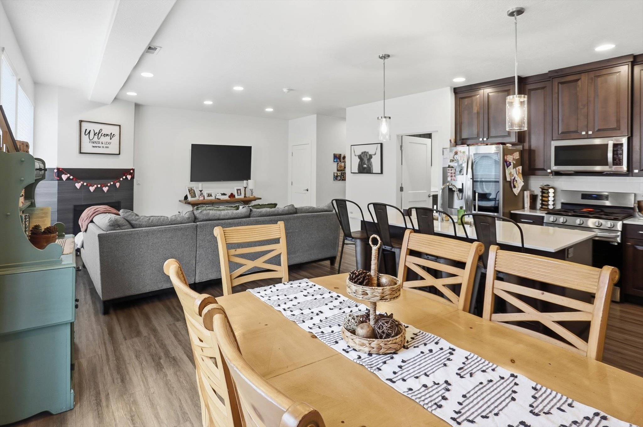 Dining space with dark wood-style floors, recessed lighting, and a fireplace