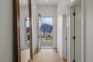 Doorway with wood finished floors, a mountain view, and recessed lighting