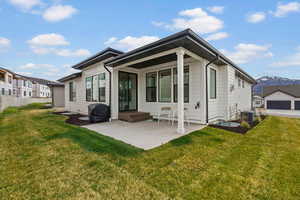 Rear view of house featuring a lawn, a patio, and a mountain view