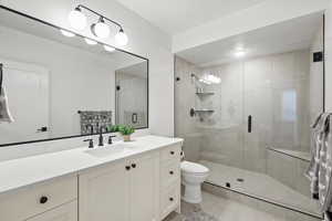 Full bath featuring vanity, a shower stall, and light tile patterned flooring