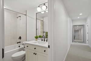 Bathroom featuring vanity, recessed lighting, light colored carpet, and shower / tub combo with curtain