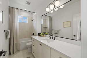 Full bath with vanity, shower / bath combination with curtain, and light tile patterned floors