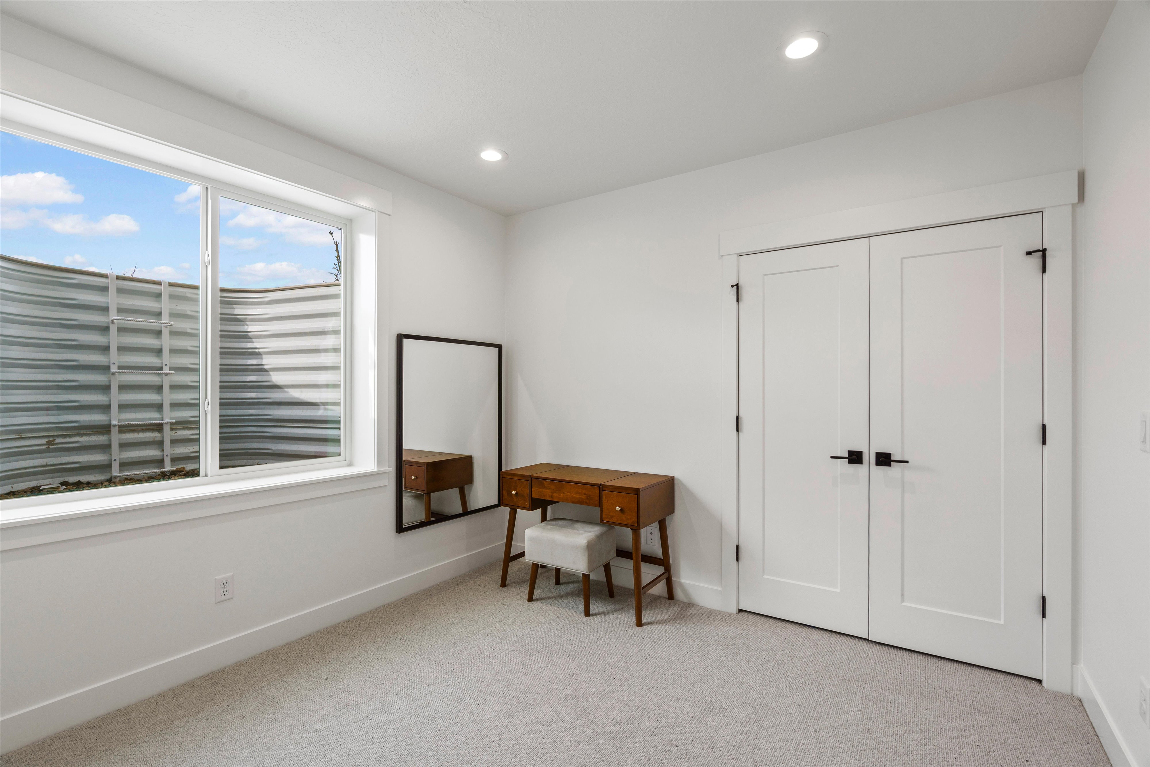 Sitting room with light colored carpet and recessed lighting