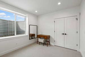 Sitting room with light colored carpet and recessed lighting