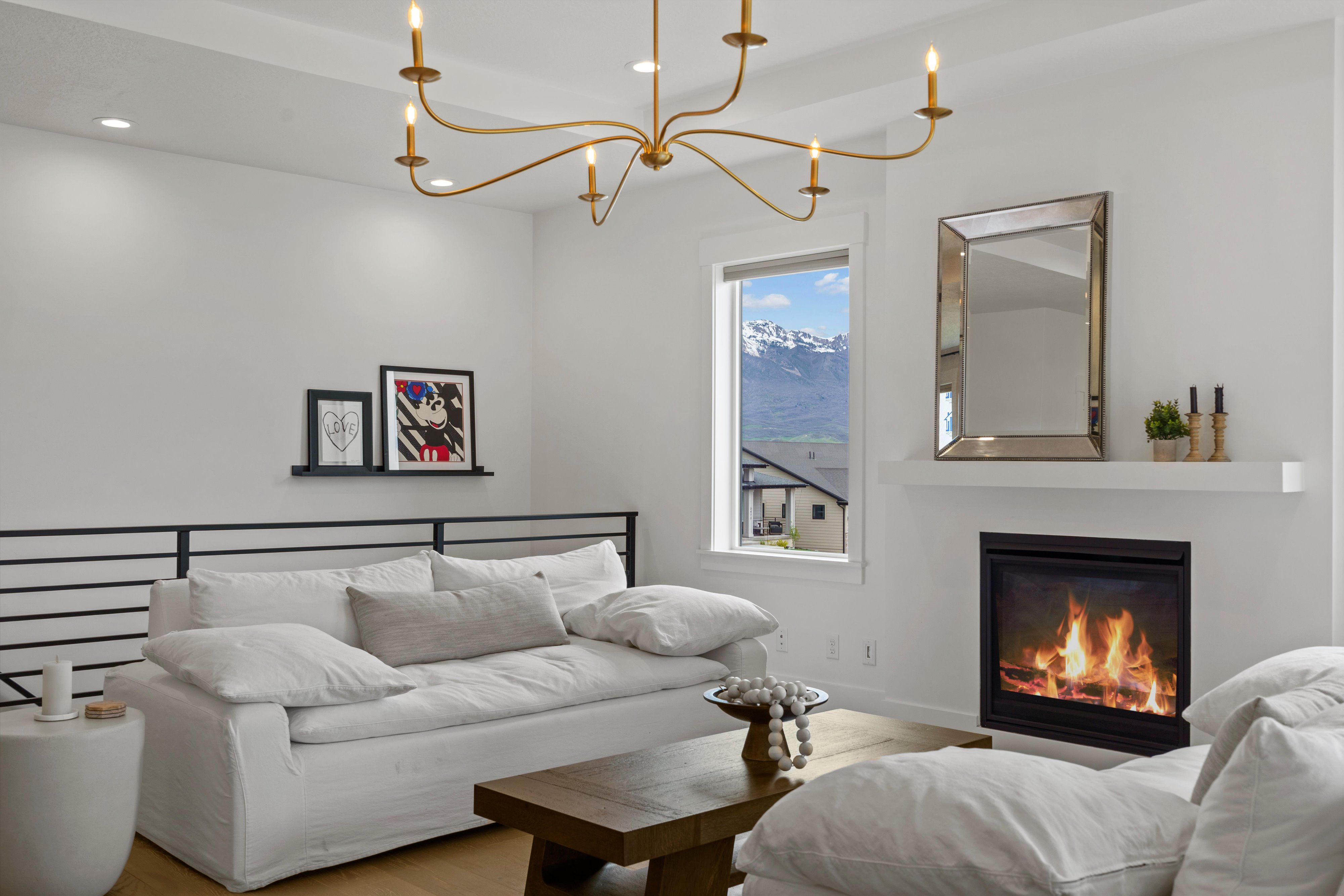 Living area with suspended lighting, wood finished floors, a glass covered fireplace, and a mountain view