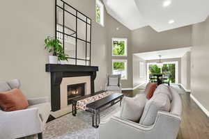 Living area featuring a fireplace, hardwood / wood-style flooring, lofted ceiling, and recessed lighting