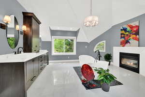 Dining area featuring a glass covered fireplace, lofted ceiling, and hanging lights