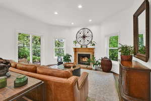 Living room featuring recessed lighting, wood finished floors, and a warm lit fireplace