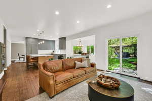 Living area with dark wood-style floors and hanging lights