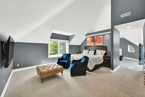 Bedroom with light colored carpet, lofted ceiling, and recessed lighting
