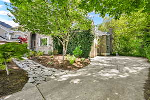 Obstructed view of property featuring brick siding, driveway, and a chimney