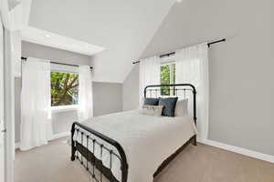 Bedroom with lofted ceiling, light carpet, multiple windows, and recessed lighting