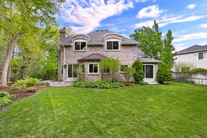 French country inspired facade featuring brick siding and a chimney