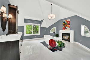 Dining space featuring a glass covered fireplace, lofted ceiling, and hanging lights