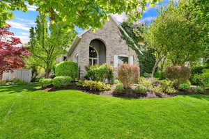 View of side of property featuring brick siding and a lawn