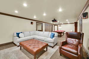 Carpeted living room featuring billiards table, crown molding, and recessed lighting
