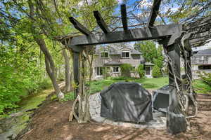 View of grassy yard featuring a patio and a pergola