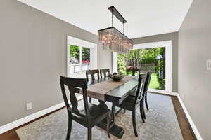 Dining space with wood finished floors and a chandelier