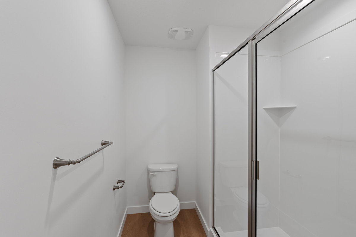 Bathroom featuring a shower stall and light wood-type flooring