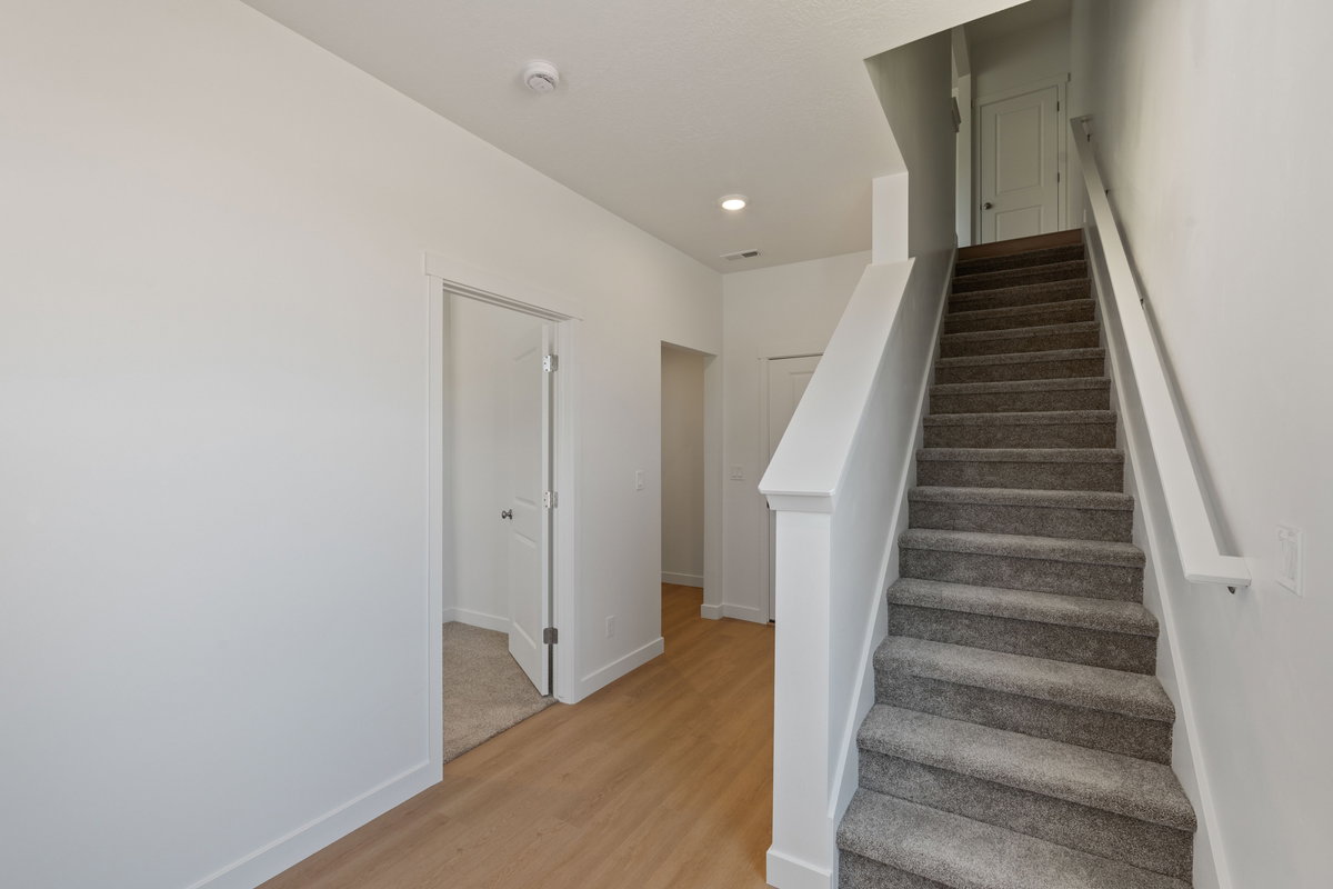 Stairway featuring wood finished floors and recessed lighting