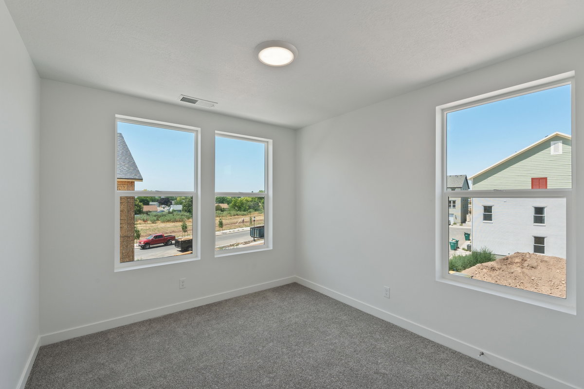 Unfurnished room featuring dark carpet and plenty of natural light