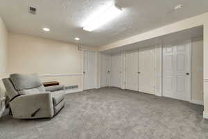 Sitting room featuring a textured ceiling, carpet, and recessed lighting