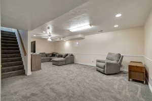 Living room featuring recessed lighting, light carpet, ceiling fan, and a textured ceiling